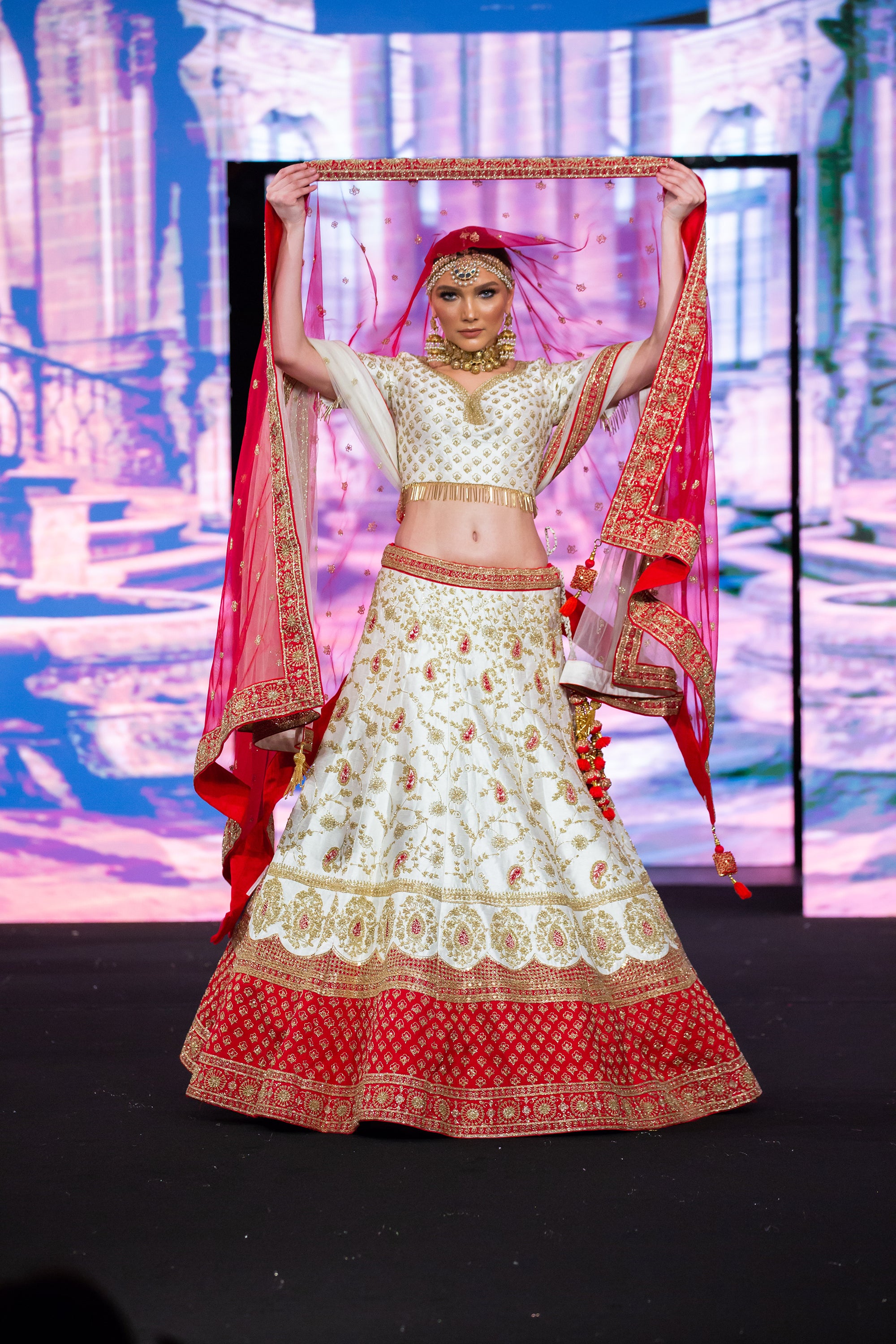 red and white indian wedding dresses Bride in Red-and-Gold Lehenga Embracing Groom in White Sherwani, Turban in  Tropical Courtyard